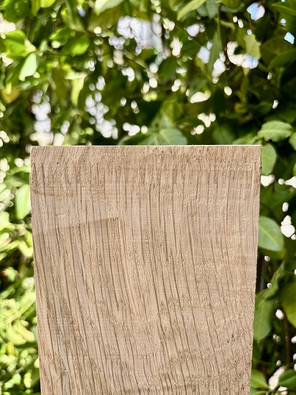 Holz mit Keilzinkung vor grünen Blätter