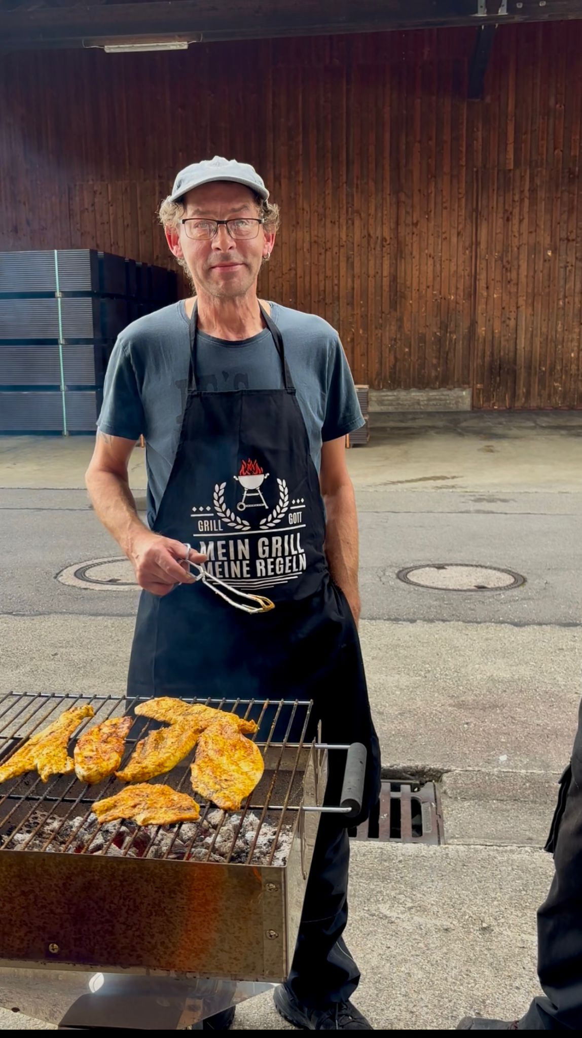 Mann steht hinter Grill