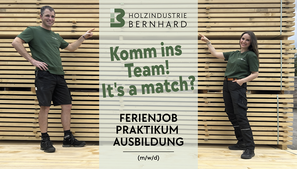 Zwei Menschen vor einem Holzstapel zeigen auf ein Banner
